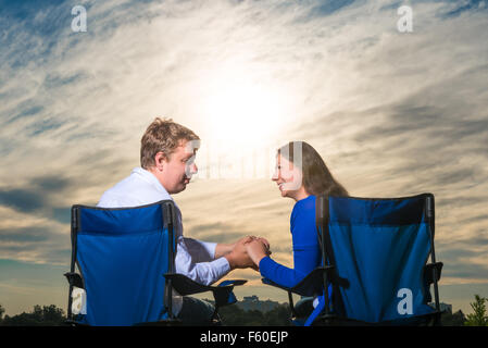 married couple sitting in chairs at dawn Stock Photo