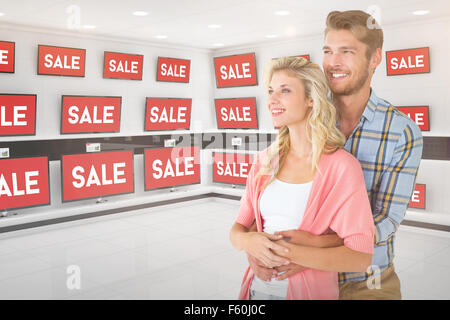 Composite image of attractive young couple embracing and smiling Stock Photo
