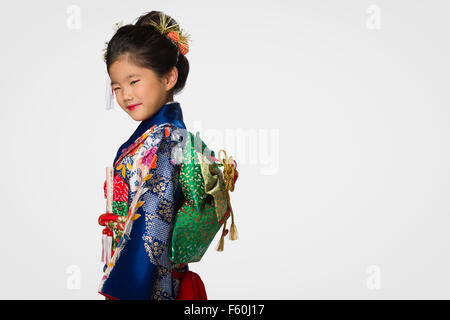 A cute young Japanese girl wearing a Kimono on a white background. Stock Photo