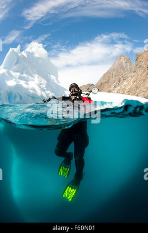 Over/under shot of diver and iceberg Stock Photo