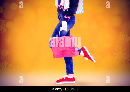 Composite image of festive blonde holding shopping bags Stock Photo