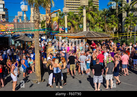 Benidorm, Spain. 10th November, 2015. British tourists in the resort for the annual Fiesta enjoy the hot autumn weather with cool drinks in the seafront bars. Crowds outside the beachfront Tiki Bar. Stock Photo
