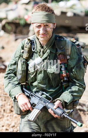 Vietnam war re-enactment, MACV-SOG special operations soldier wearing bandana headband and holding assault rifle in hands. Facing, eye-contact Stock Photo