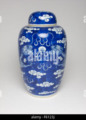 Antique Chinese 19th century blue and white vase and cover painted with dragons chasing a flaming pearl. Stock Photo