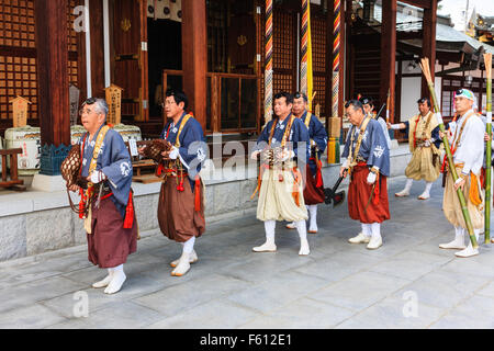 Japan, Nishinomiya, Mondo Yakuji temple. Possession of Priests wearing yamabushi, (Warrior monk), costumes, walking in line pass temple hall. Stock Photo