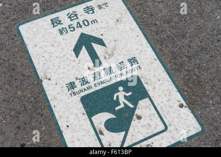 A tsunami evacuation route sign on a pavement in Japan. Stock Photo