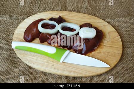 chicken liver with onions on a cutting board and knife Stock Photo