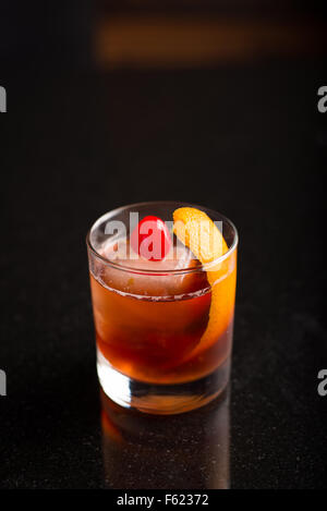 Old-fashioned cocktail on with a dark background. Stock Photo