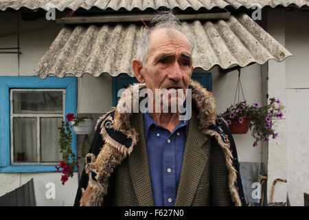 The returnee Ivan Ilchenko (82) in front of his house in the village Kupovate, located in the Chernobyl Exclusion Zone. Ukraine Stock Photo