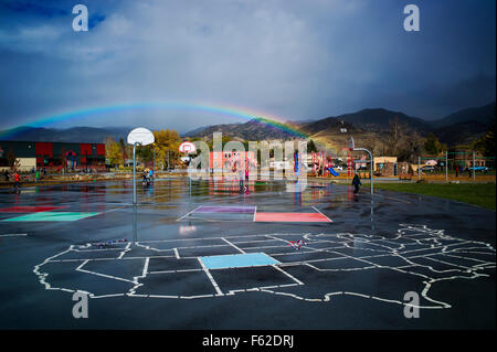 Rainbow over elementary school playground in small mountain town of Salida, Colorado, USA Stock Photo