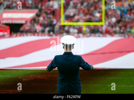 Santa Clara, CA. 8th Nov, 2015. A US service member holds the American flag prior to the NFL football game between the Atlanta Falcons and the San Francisco 49ers at Levi's Stadium in Santa Clara, CA. The 49ers defeated the Falcons 17-16. Damon Tarver/Cal Sport Media/Alamy Live News Stock Photo