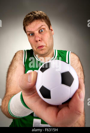 Portrait of surprised basketball player with football Stock Photo