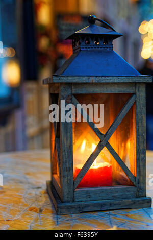 https://l450v.alamy.com/450v/f6395y/burning-lantern-on-wooden-surface-and-blurred-background-garmisch-f6395y.jpg