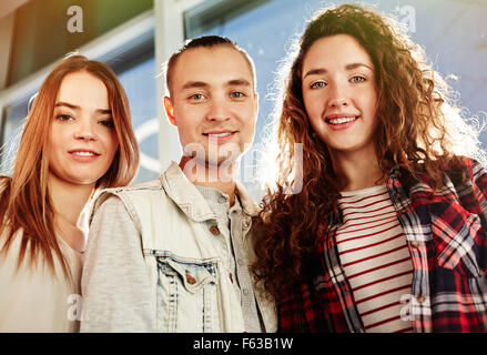Three young friends in casual-wear looking at camera Stock Photo