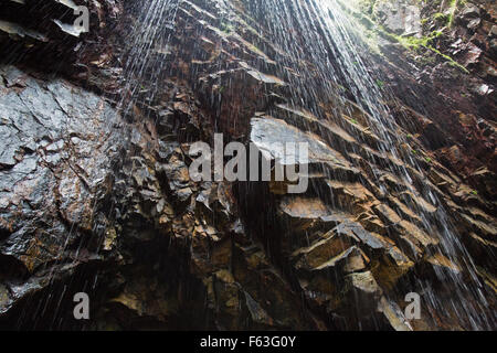 Looking up towards the top of a small waterfall in amongst the rocks on Plemont Bay, on the channel island of Jersey. Stock Photo