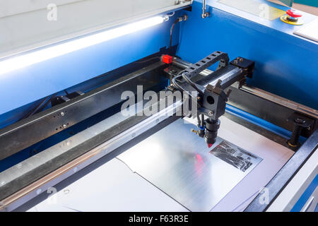 Laser machine is cutting an image on a flat sheet ot steel in a university laboratory. Stock Photo