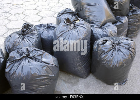 Premium Photo  Heap of plastic trash bags on curb waiting for sanitation  pickup.