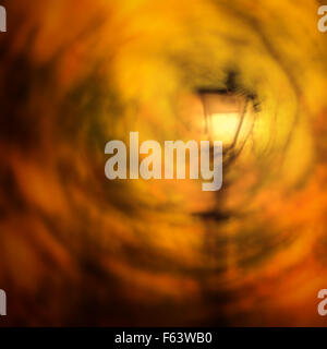 Lamppost in an autumn breeze - quirky abstract of swirling autumn leaves Stock Photo