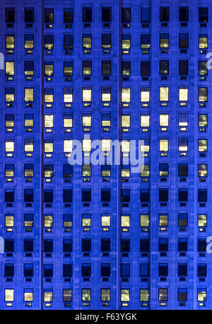 exterior blue light on windows on a hight office building Stock Photo