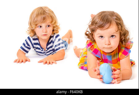 Funny boy and girl are lying together isolated on white background. Focus on little boy. Stock Photo