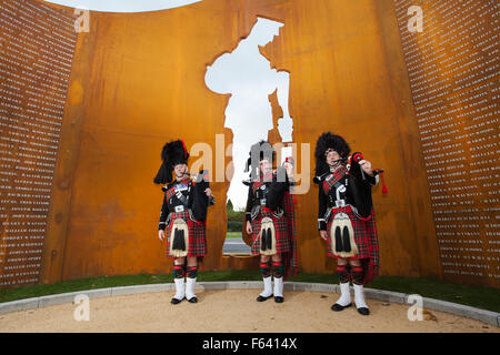 New First World War 1 Memorial in Lostock Hall, Preston, Lancashire 11th November, 2015. Preston Scottish Pipe Band members at the Commemoration of First World War (1914-1918) The 40ft monument , a sculpture depicting a First World War soldier is new war memorial commemorating more than 600 fallen soldiers from South Ribble. The rusty metal engraved war structure was opened at a dedication ceremony on Armistice Day with members of the fallen soldiers families invited. Stock Photo