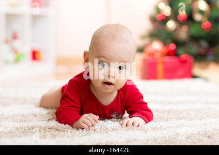 Funny baby in Santa Claus clothes with xmas tree Stock Photo