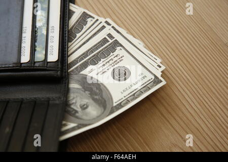 Black leather wallet full of money Stock Photo