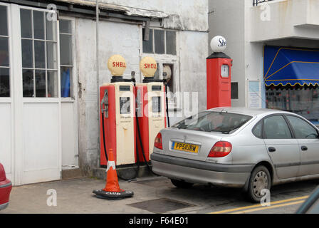 three old redundant petrol pumps outside garage,St Mawes, Cornwall Stock Photo