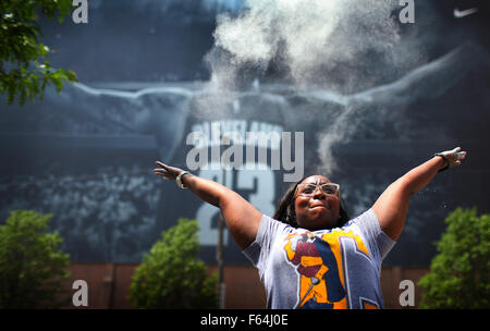 Cleveland, Ohio, USA. 8th June, 2015. Cleveland, Ohio June 9, 2015.Cleveland Cavilers fan Kendra Davis throws powder in the air outside the Q in front of the LeBron James banner. Davis was with a group from the United Way of Greater Cleveland who are having a fun social media rivalry with the United Way of the Bay area. (Michael F. McElroy © Michael F. Mcelroy/ZUMA Wire/Alamy Live News Stock Photo