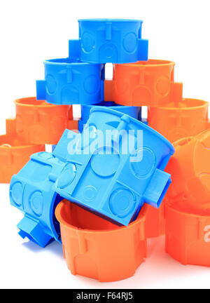 Blue and orange plastic electrical boxes on white background, components for use in electrical installations, Stock Photo