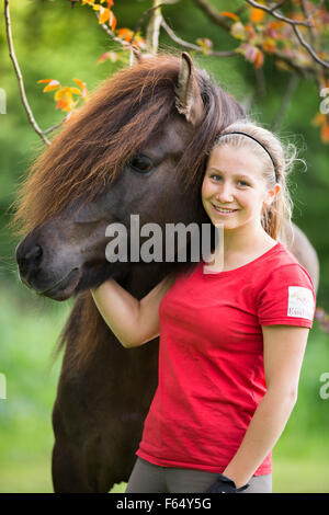 Icelandic Horse. Girl standing next to bay stallion. Austria Stock Photo