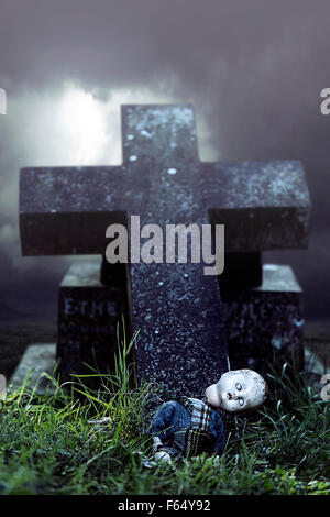 a broken doll on a grave Stock Photo