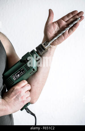 ILLUSTRATION - A man holds a drilling machine in Dresden (Saxony), Germany, 19 February 2015. Photo: Thomas Eisenhuth Stock Photo