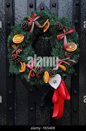 A Christmas garland, or wreath hanging on the wooden front door of a cottage in an English village Stock Photo