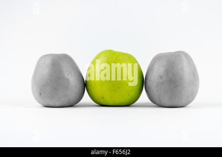 Three green apples on a white background, middle one desaturated Stock Photo