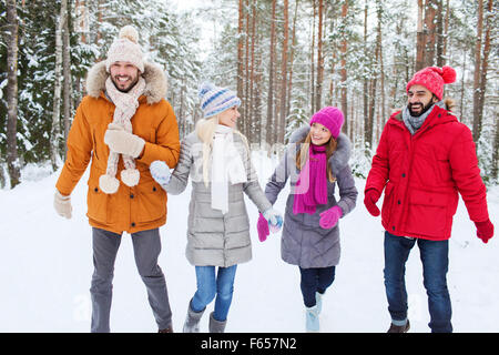 group of smiling men and women in winter forest Stock Photo