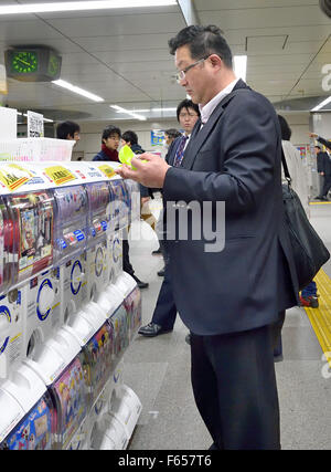 Tokyo, Japan. 11th Nov, 2015. Evening commuters in Akihabara station, Tokyo, Japan using Toy-dispensing machines called 'gacha gacha, ' which is named after the handle-turning noise that precedes the release of the plastic capsule. © Rory Merry/ZUMA Wire/Alamy Live News Stock Photo