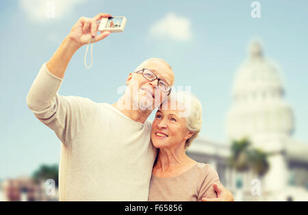 senior couple with camera over white house Stock Photo