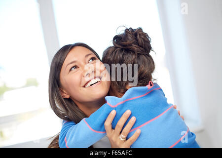 happy mother and daughter hugging at home Stock Photo