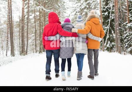 group of happy men and women in winter forest Stock Photo