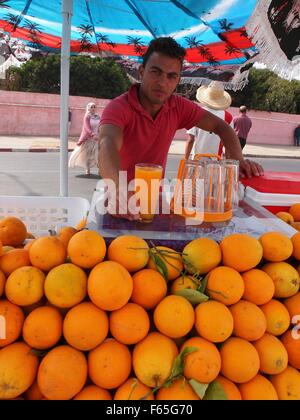 A young man selling freshly pressed orange juice on the outskirts of El Jadida, Morocco Stock Photo