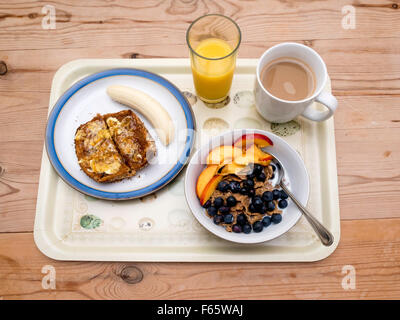 A breakfast tray cereal bran flakes with blueberries and nectarine multiseed toast   marmalade banana coffee and orange juice Stock Photo