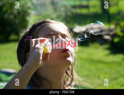 Little girl blowing soap bubbles Stock Photo