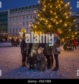 People taking pictures by the large Christmas tree, Austurvollur square, Reykjavik, Iceland Stock Photo