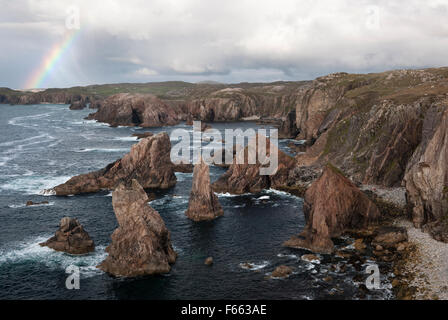 Geodh' an Fhithich: a group of sea stacks formed by erosion of cliffs SW of Mangersta beach & Rubh' an Taroin headland with rainbow, Isle of Lewis. Stock Photo