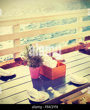 Vintage toned table setting on pier at sunset, California, USA. Stock Photo