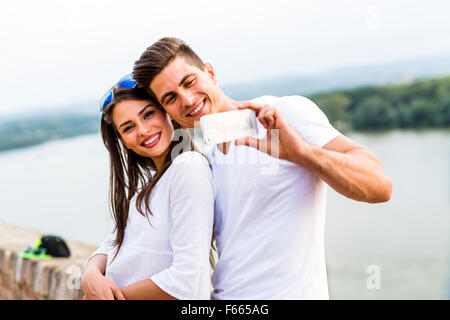 Young beautiful couple taking a selfie of themselves and being happy