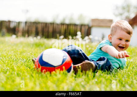 Adorable small boy playing with a soccer ball outdoors Stock Photo