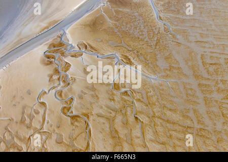 Aerial view of winding stream running through tidal mudflat Stock Photo