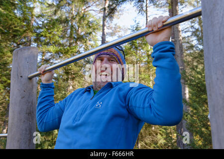 Man doing pull-ups on a bar, Naturschauspiel Kreuth, adventure trail along the Weissach, Weissach near Kreuth, Upper Bavaria Stock Photo